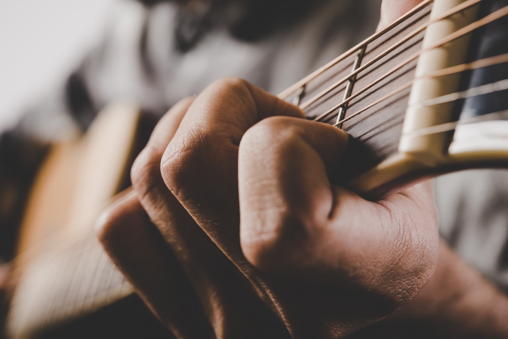 Mão no braço do violão fazendo um acorde